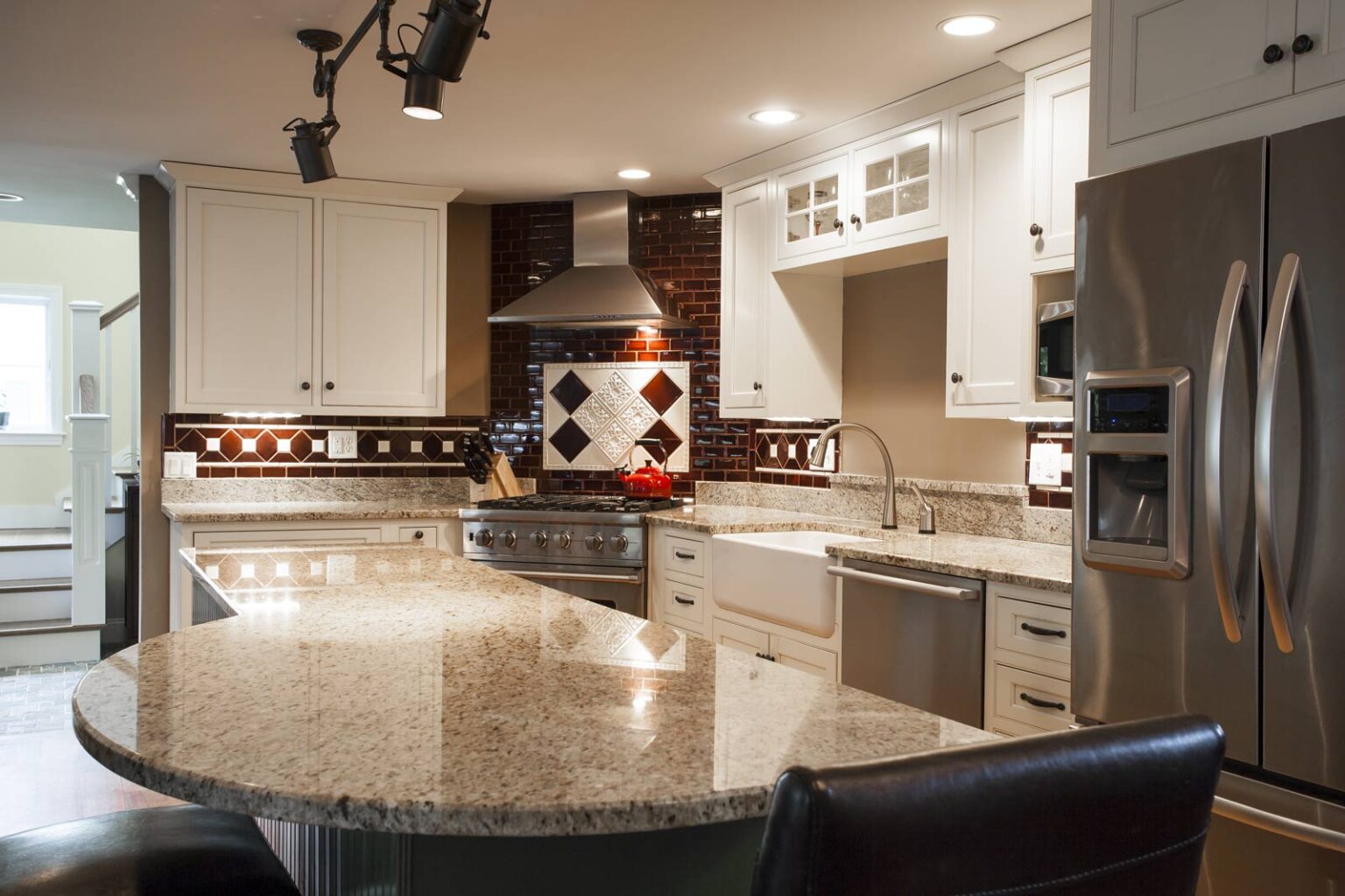 This curved island has a St. Cecile light granite countertop