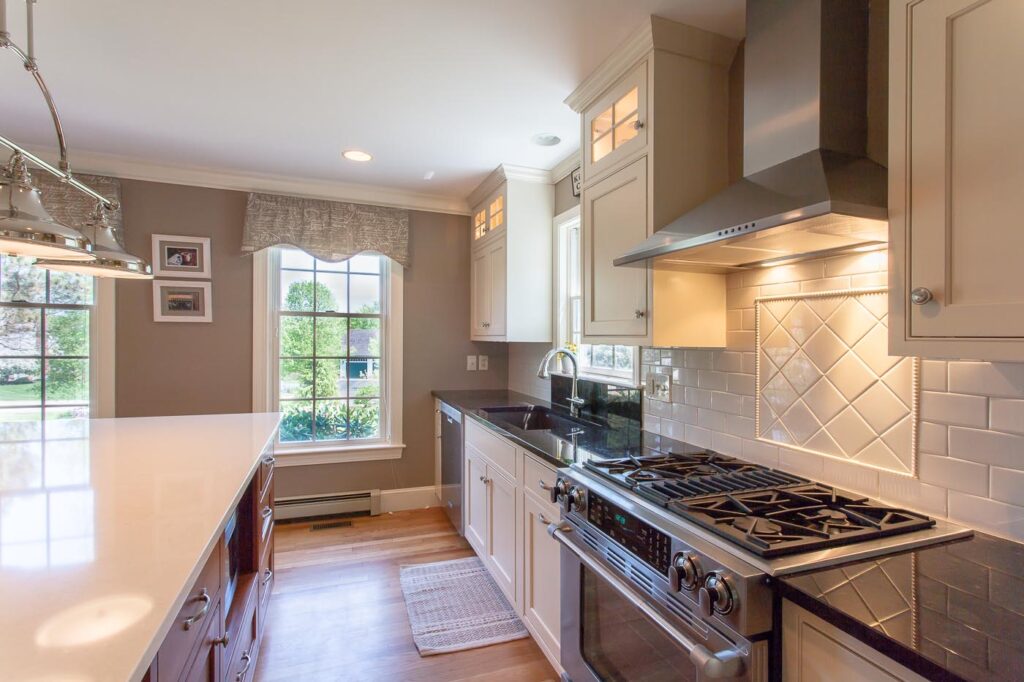 Kitchen with neutral tones, dark units with light tops and light cabinets with dark tops